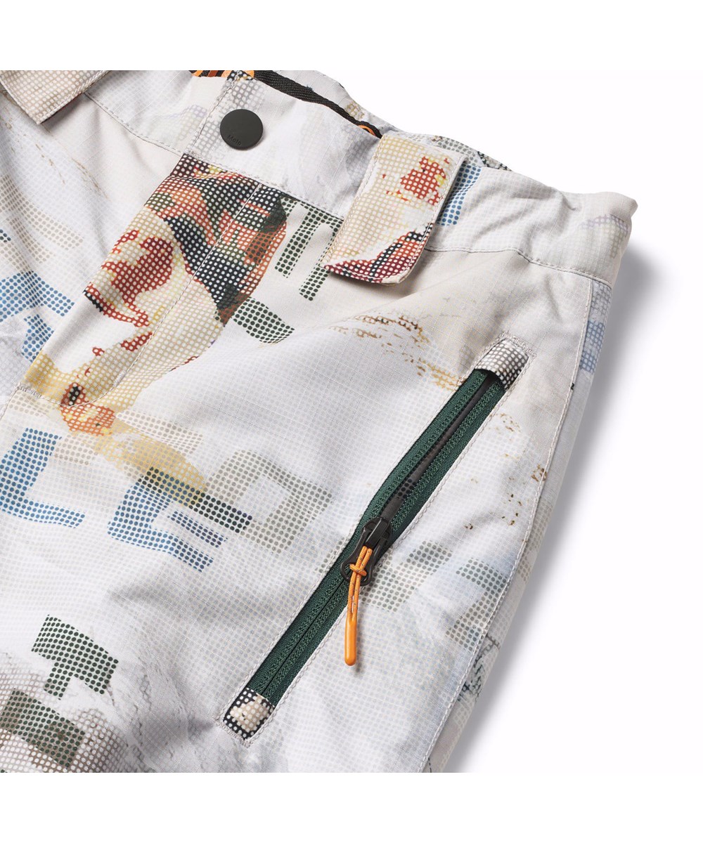 Jump Pro - Spin 1260 - Wind- en waterdichte skibroek voor kinderen van gerecycled polyester met een pixelprint van een stoere snowboarder in de Alpen.