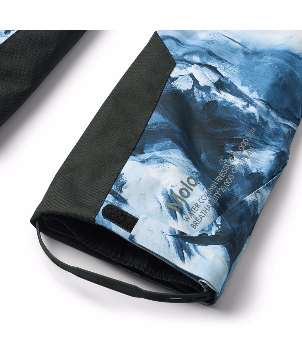 Jump Pro - Arty Mountains - Wind- en waterdichte kinderskibroek met een artistieke print van de Alpen en snowboarders in blauwe en witte tinten. Gemaakt van gerecycled polyester en gevoerd met 3M™ Thinsulate™.