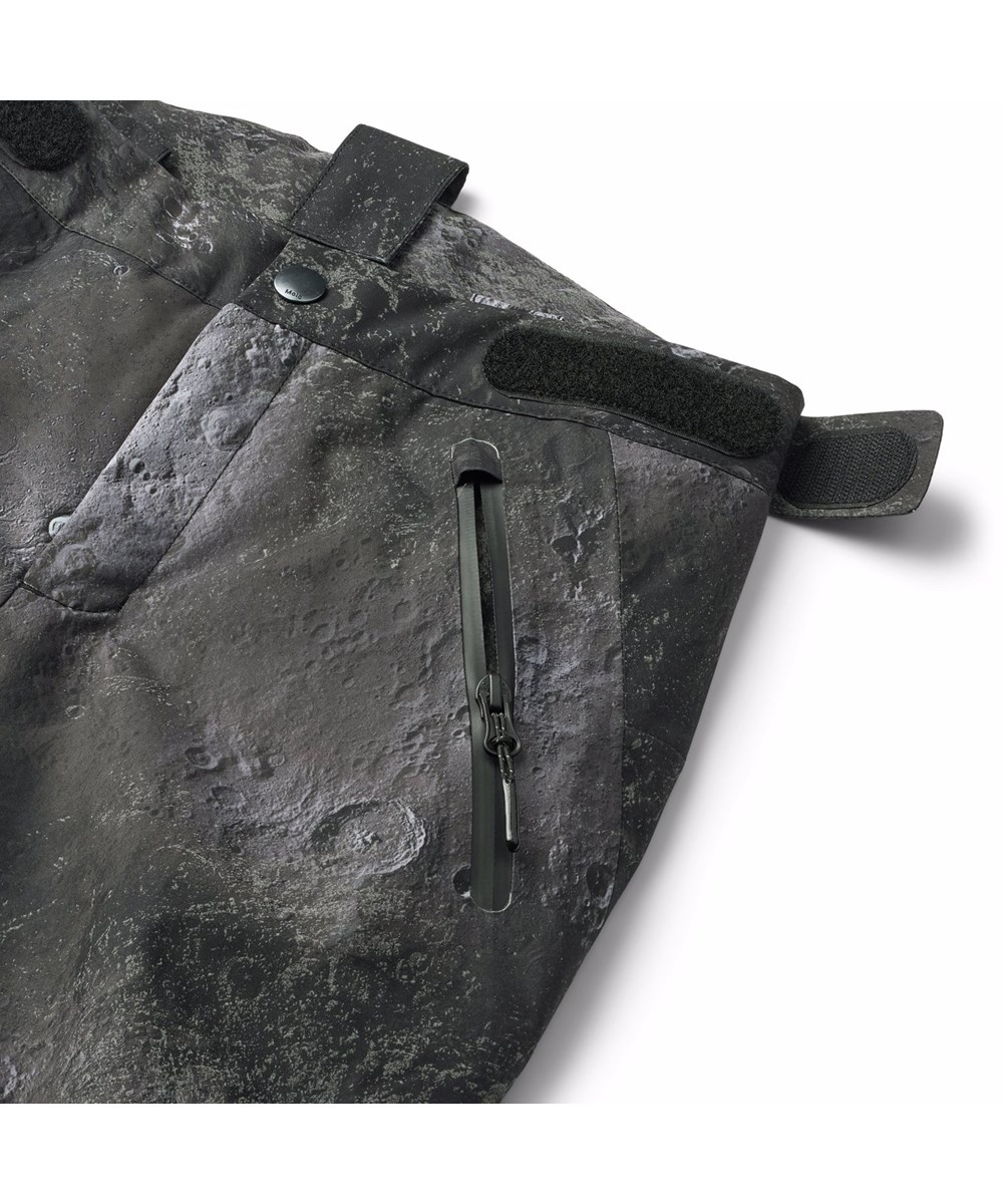 Jump Pro - Moon - Wind- en waterdichte kinderskibroek met een print van de ruwe structuren van de maan en zijn donkere en lichte tinten. Gemaakt van gerecycled polyester en gevoerd met 3M™ Thinsulate™.