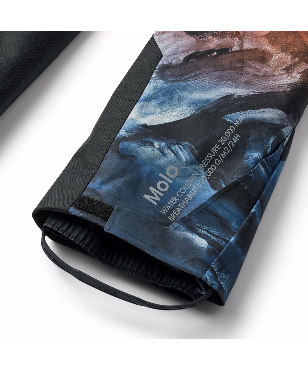 Jump Pro - Sunrise - Wind- en waterdichte kinderskibroek in grijs, oranje en blauw met een print van snowboarders in de Alpen. Gemaakt van gerecycled polyester en gevoerd met 3M™ Thinsulate™.