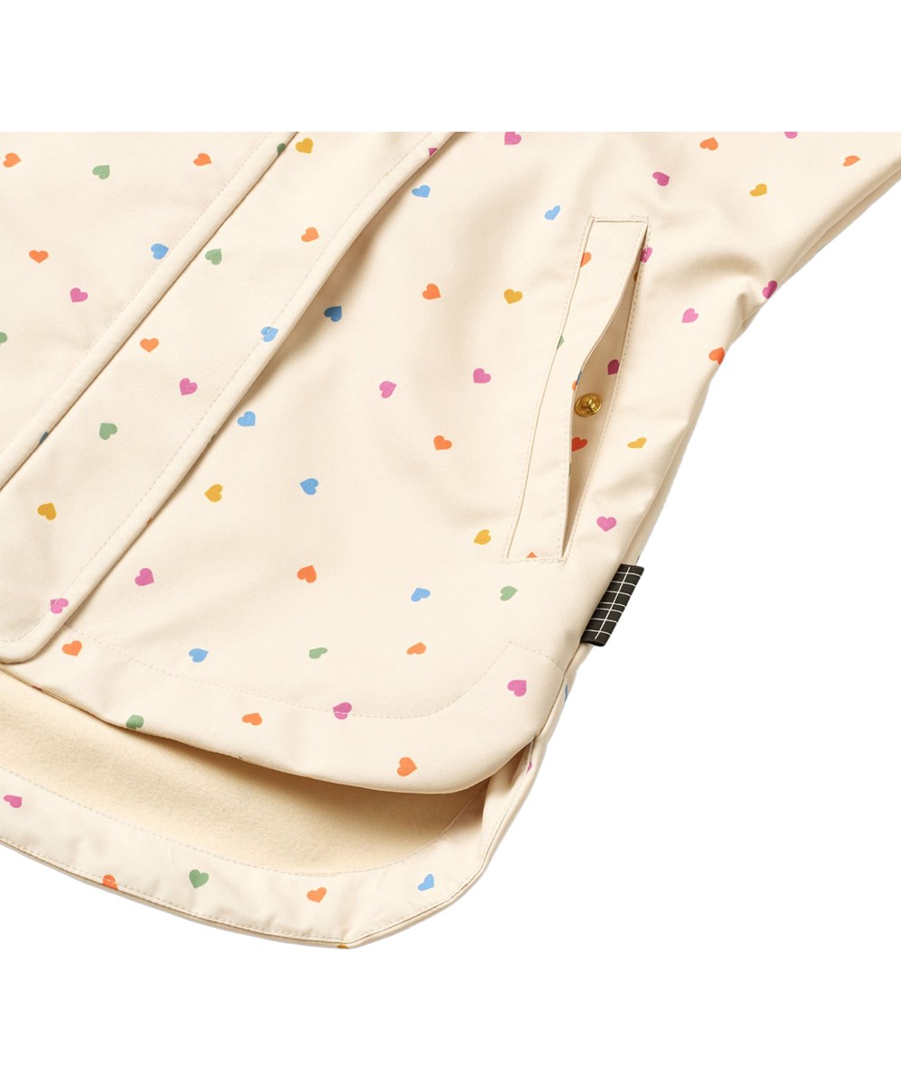 Hillary - Confetti_Rainbow - Wind- en waterafstotende jas voor kinderen gemaakt van gerecycled polyester met fleece voering en een hartjesprint in regenboogkleuren.