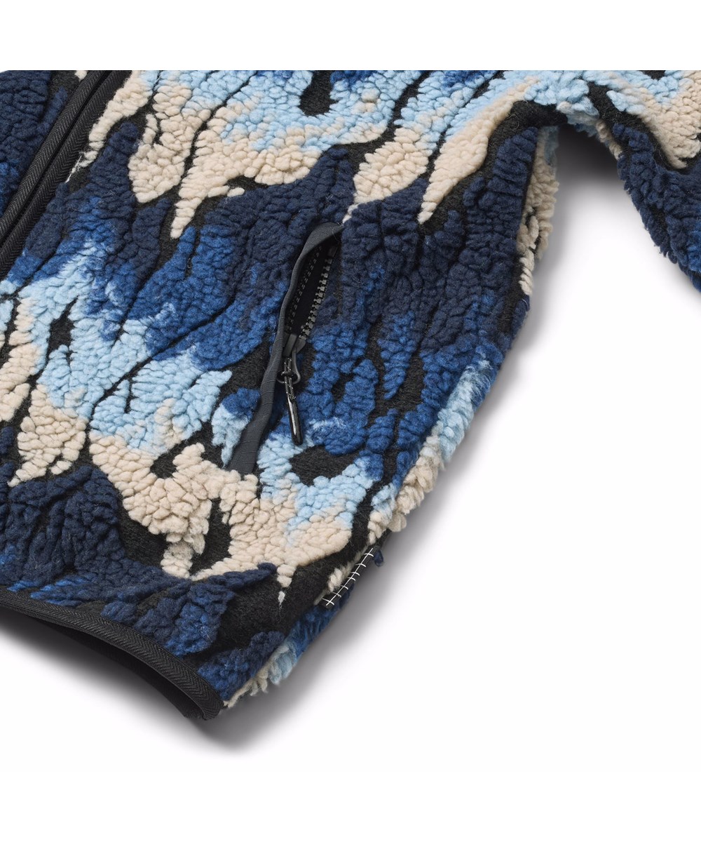 Unique - Ingenuity Cool - Zachte fleecejas voor kinderen gemaakt van gerecycled polyester met bijpassende ribboorden en gevoerd met zacht katoen. De stof van de jas lijkt op vlammen in blauwe en beige tinten.