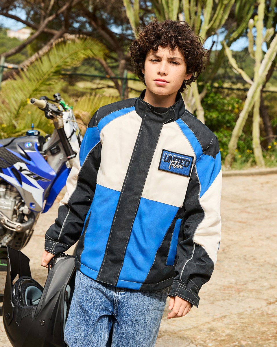 Haddix - Black - Kinderjas  in de kleuren zwart, blauw en gebroken wit en het is geinspireerd op de motorcross wereld met klittenband en patches.