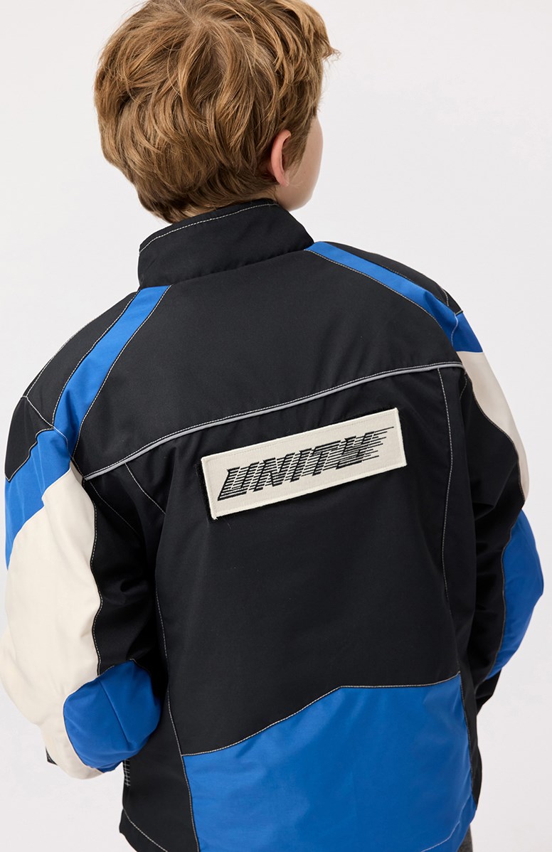 Haddix - Black - Kinderjas  in de kleuren zwart, blauw en gebroken wit en het is geinspireerd op de motorcross wereld met klittenband en patches.