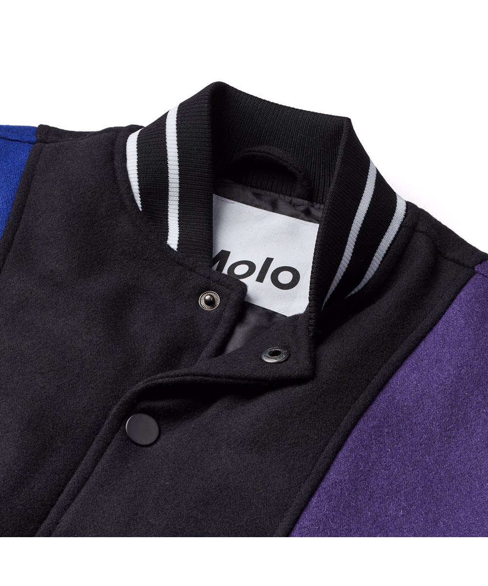 Hani - More Colours - Baseballjas in zwart, blauw, groen en paarse kleuren gemaakt van een stevige wolmix.