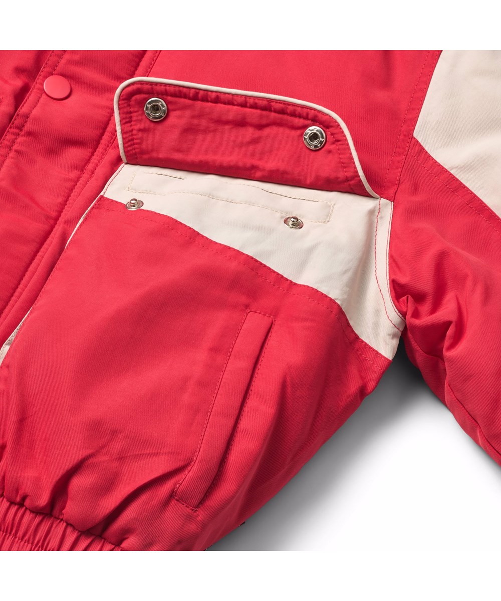 Herold - Vivid - Rode en witte jas voor kinderen met op de achterkant en de mouwen de geborduurde tekst "Ingenuity humankind freedom".