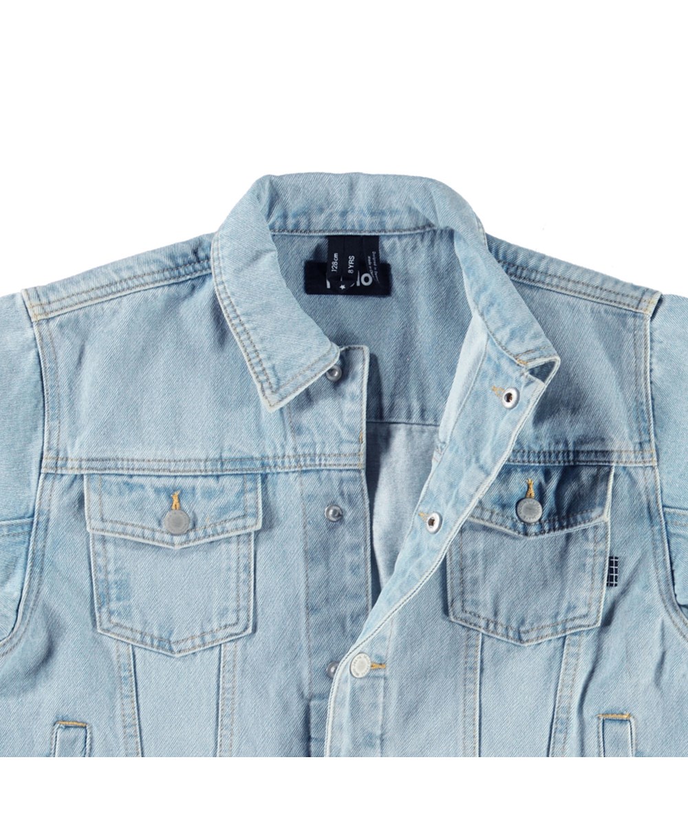 Honore - Sun-Bleach Blue - Lictblauwe spijkerjas voor kinderen van katoen met op de achterkant een geborduurde bananenschil en op de mouw de tekst 'If you slip...Get back up'.