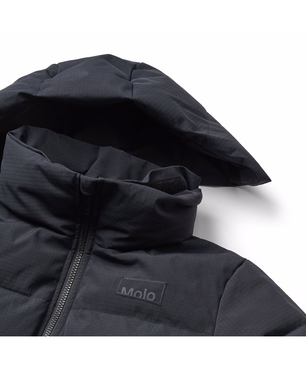 Harper - Black - Wind- en waterafstotende zwarte kinderjas gemaakt van gerecycled nylon met ritssluiting, hoge kraag en afneembare capuchon.