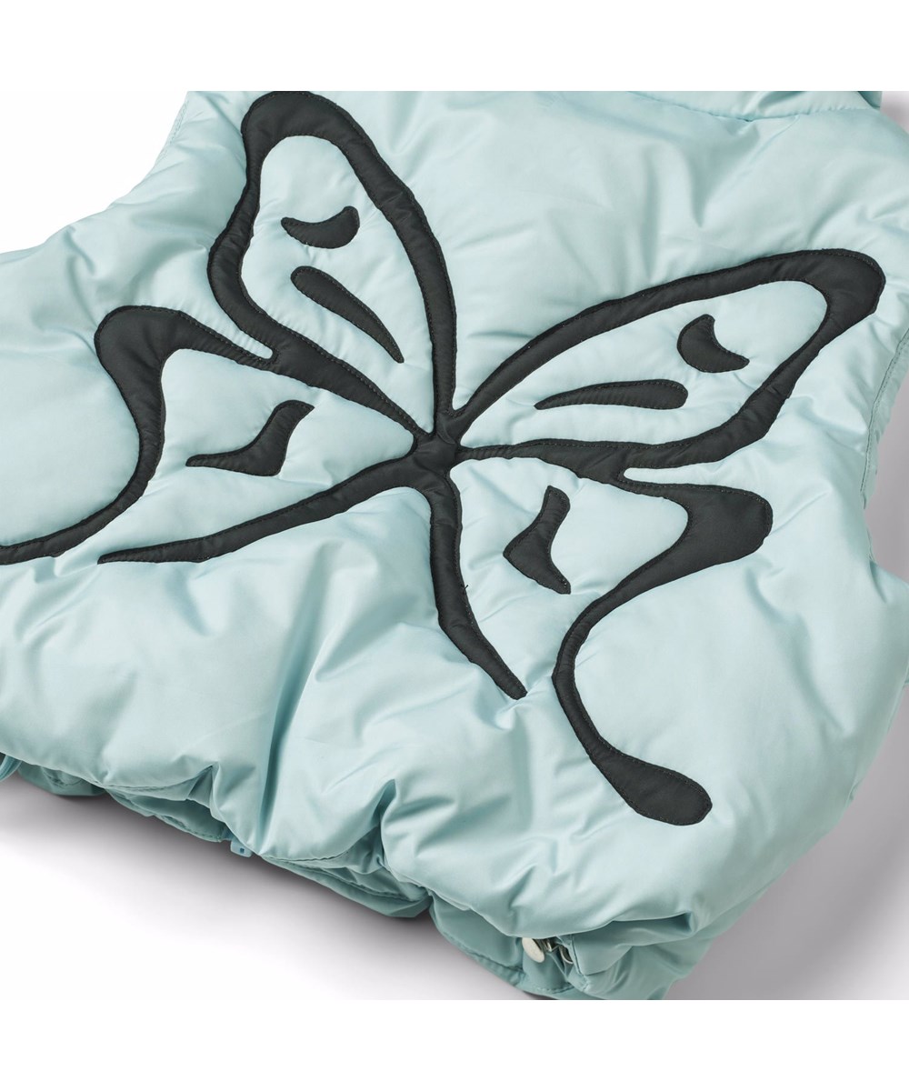 Hester - Quilt Butterfly - Lichtblauw doorgestikt vest voor kinderen van gerecycled polyester met een geborduurde zwarte vlinder op de achterkant.
