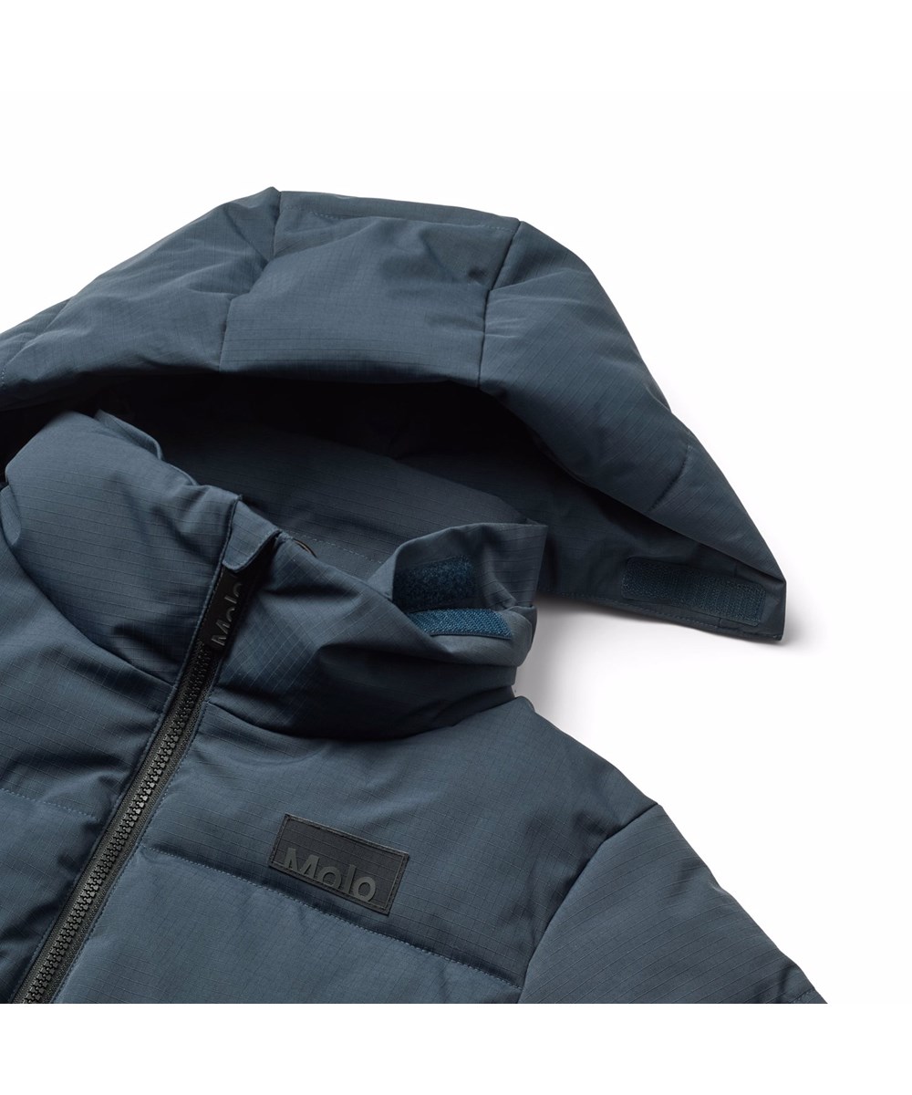 Hilo - Night Navy - Warme en functionele blauwe kinderjas gemaakt van gerecycled polyester met ritssluiting, hoge kraag en afneembare capuchon.