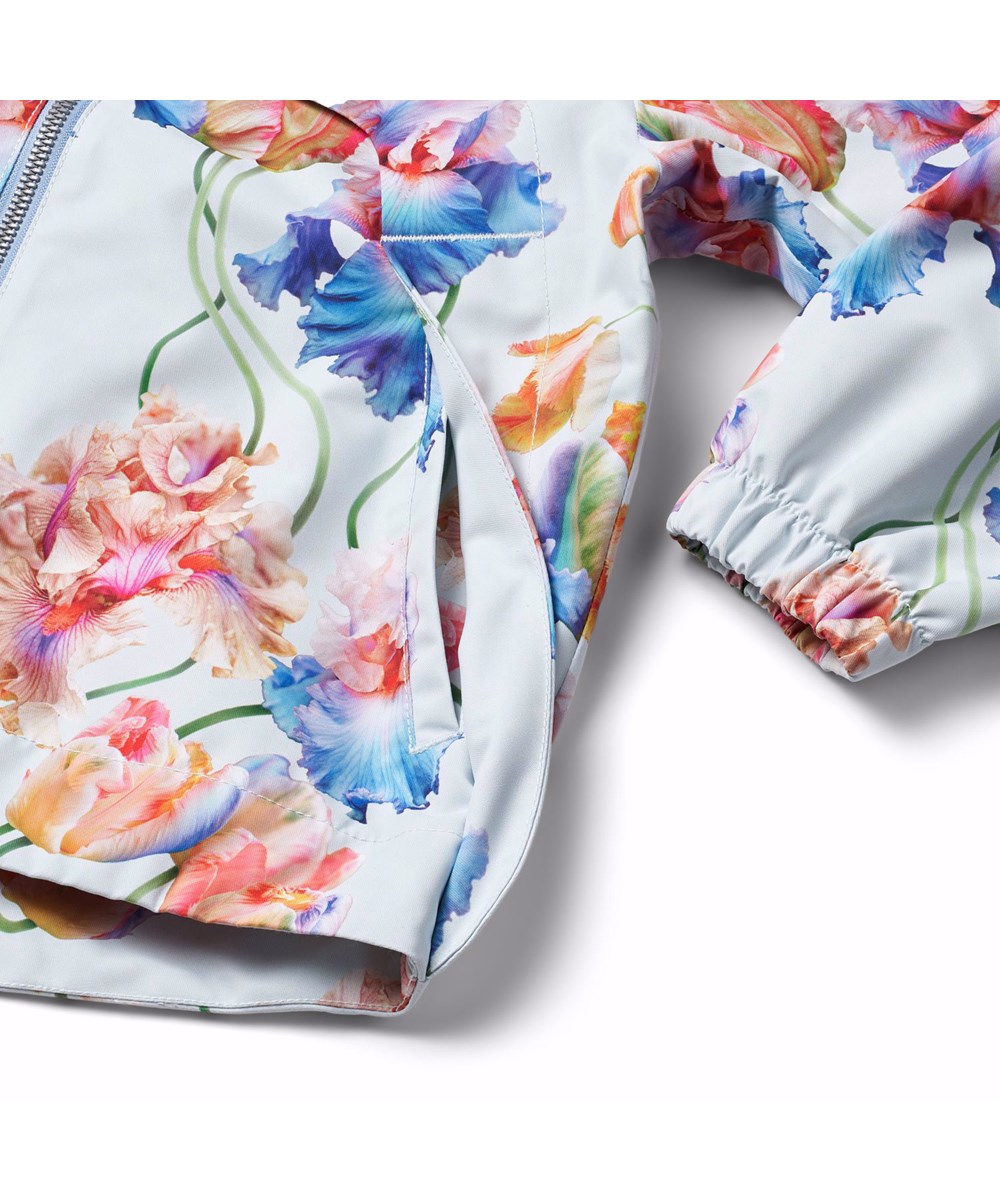 Hoplas - Tulip Blue - Lichtblauwe wind- en waterdichte kinderjas  van gerecycled polyester met een kleurrijke all over print van artistieke tulpen.