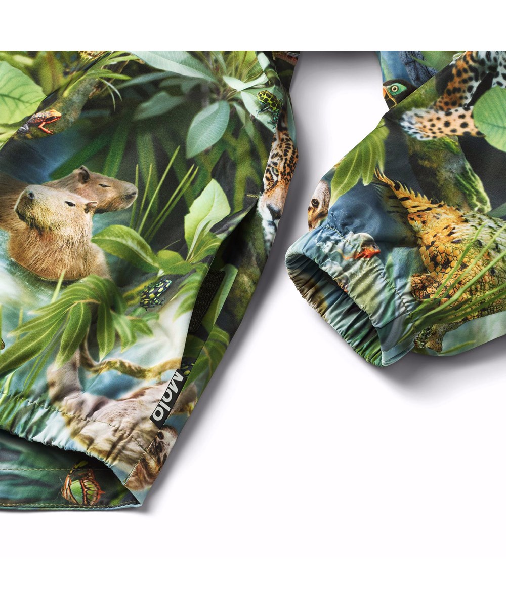 Whalley - Jungle Life - Groene wind- en waterdichte regenpak van gerecycled polyester met een all over print van de jungle en zijn kleurrijke dieren.