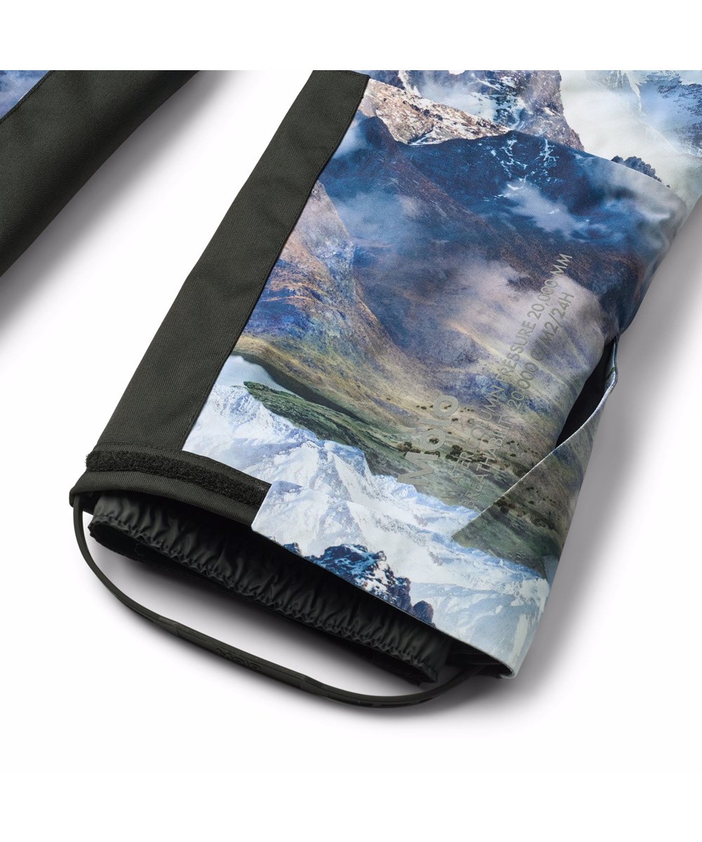 Hux - Snowy Mountains - Wind- en waterdicht skipak voor een kouden winter of skivakantie met een prachtige landschapsprint met besneeuwde bergtoppen in levendige kleuren gemaakt van gerecycled polyester en gevoerd met 3M™ Thinsulate™.