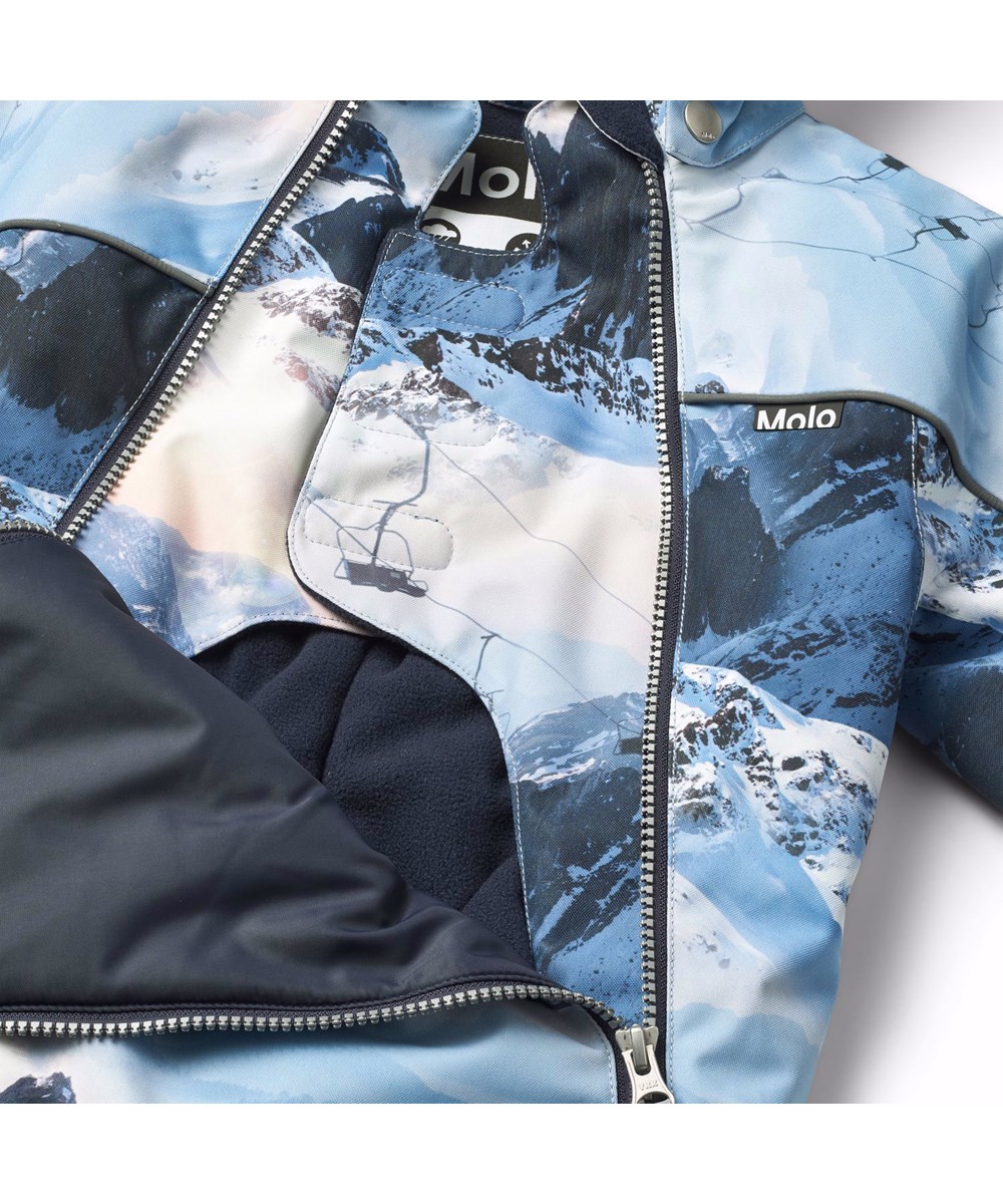 Pyxis - Mountain High - Kinder skipak van gerecycled polyester met een print van een winterlandschap in verschillende tinten blauw.