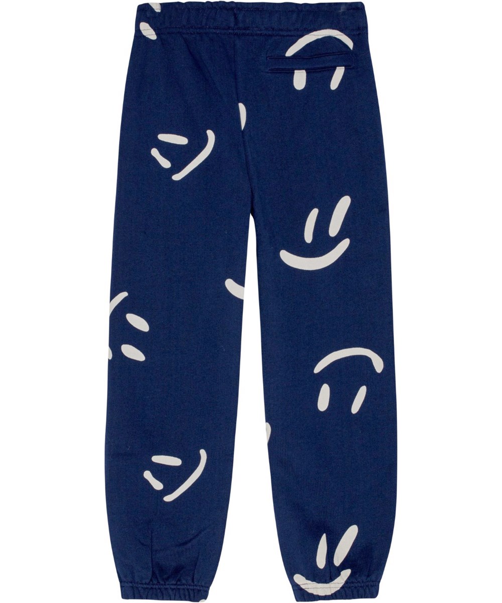 Adan - Big Smiles Navy - Dark blue organic cotton sweatpants with all-over white smile print.