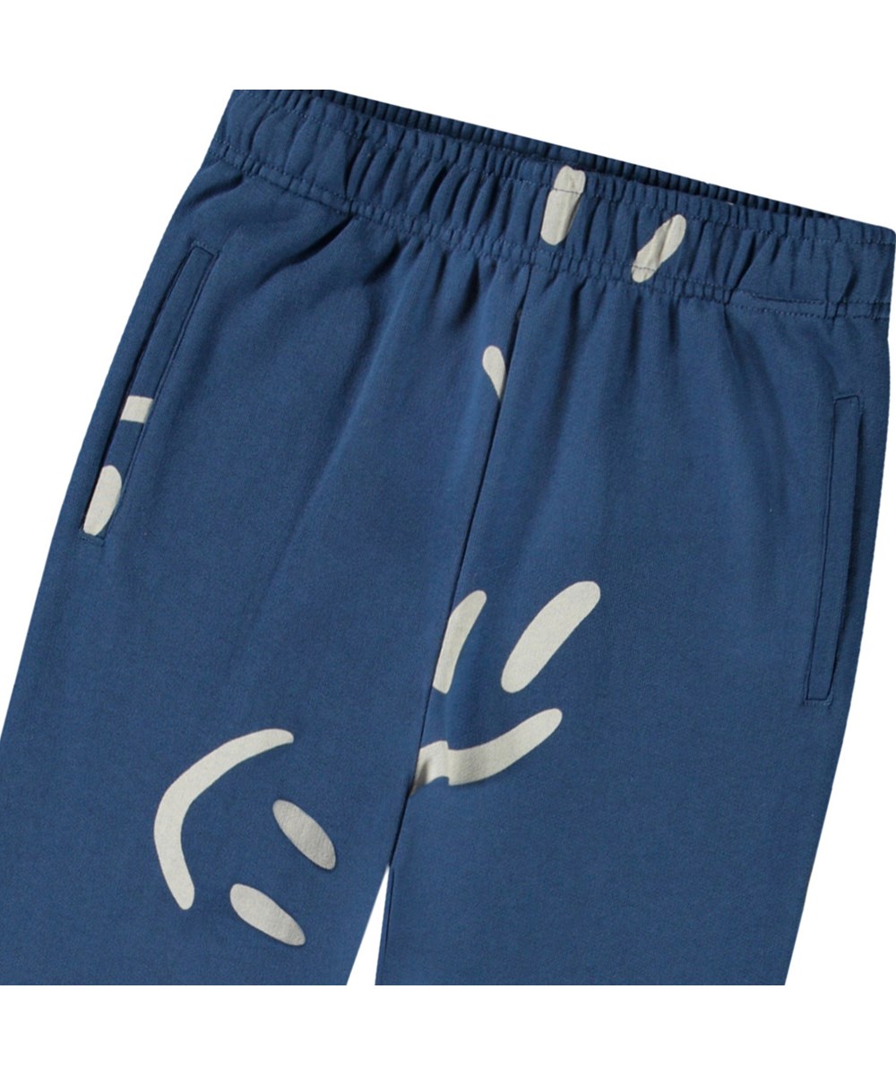 Allen - Big Smiles Blue - Blue pants in organic cotton with smiling faces for children.