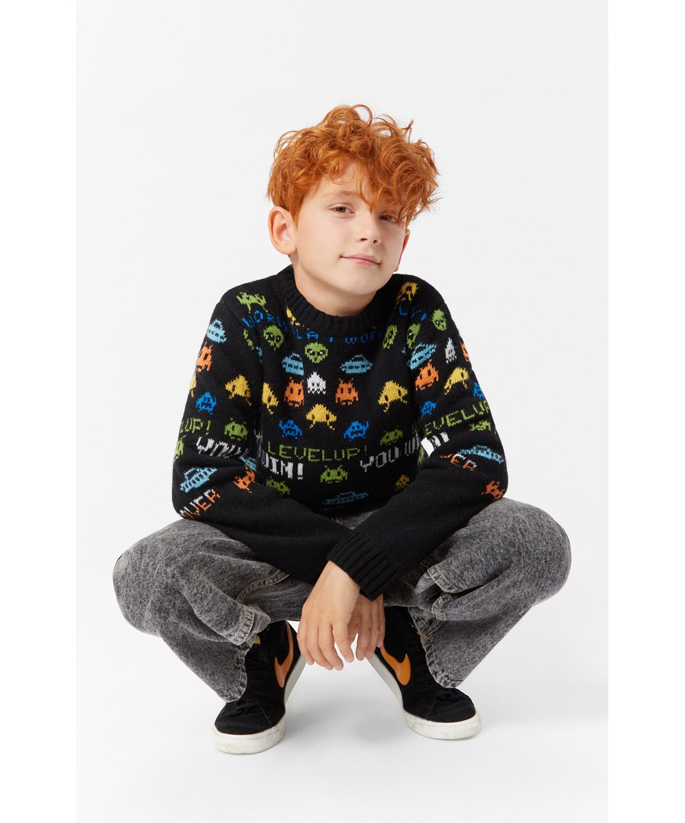 Barri - Level Up! - Black long-sleeved jumper with multicoloured pixel-inspired pattern.