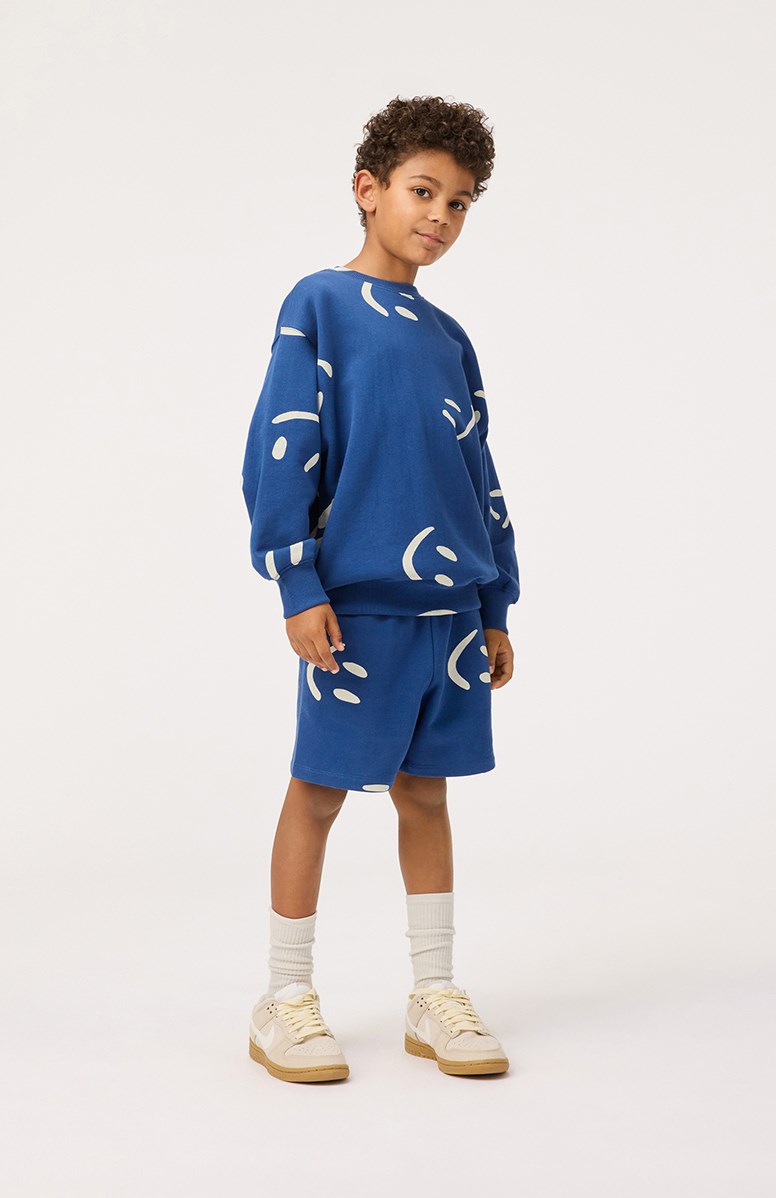 Monti - Big Smiles Blue - Dark blue sweatshirt with print for children in soft, organic cotton with ribbed edges at the neck, sleeves, and at the bottom of the sweatshirt.