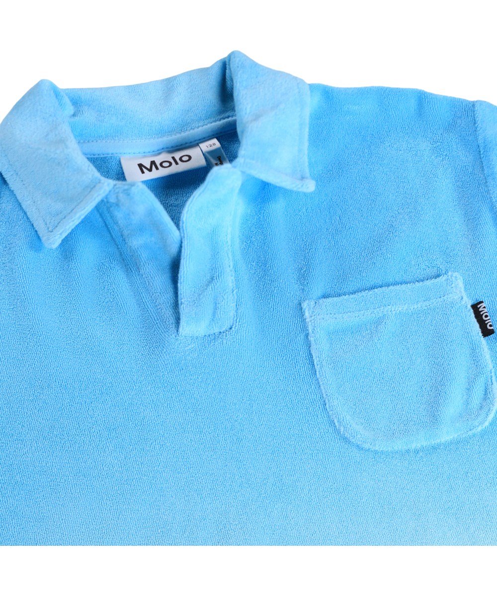 Randel - Blue Light - Blue polo T-shirt for children made of organic cotton terry with short sleeves and collar.