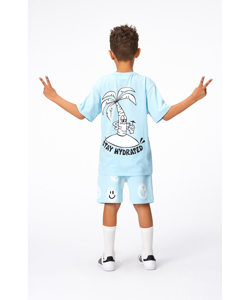 Adian - Pool Easy Peacy - Blå økologiske sweatshorts i hvidt alloverprint med smilende ansigter og peacetegn