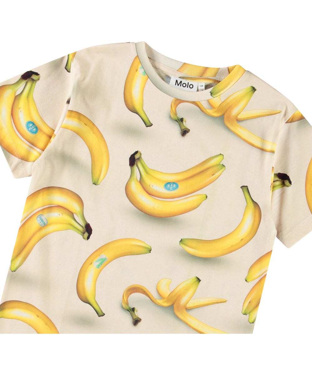 Riley - Bananas - Beige t-shirt med print til børn i blødt økologisk bomuld med korte ærmer og ribkant i halsen.