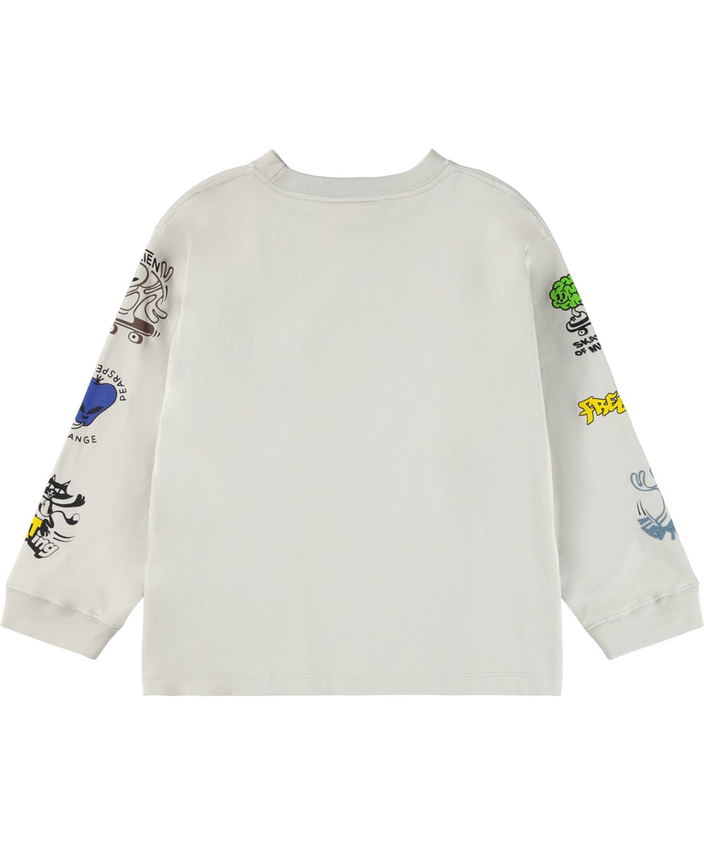 Rube - Comic Skate - Beige, langærmet bluse til børn i økologisk bomuld med ribkant i hals og ærmer med et print af aliens og katte på skateboards samt sjove og søde udsagn ned langs ærmerne.