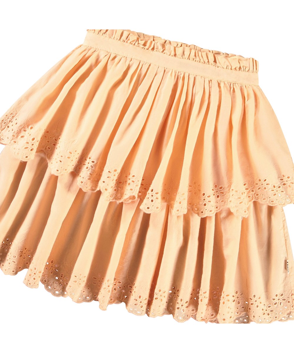 Brianna - Pale Melon - Ljusorange kjol i ekologisk bomull för barn. Kjolen är knälång och har två kjolar i olika längder med broderie anglaise längs kanten.