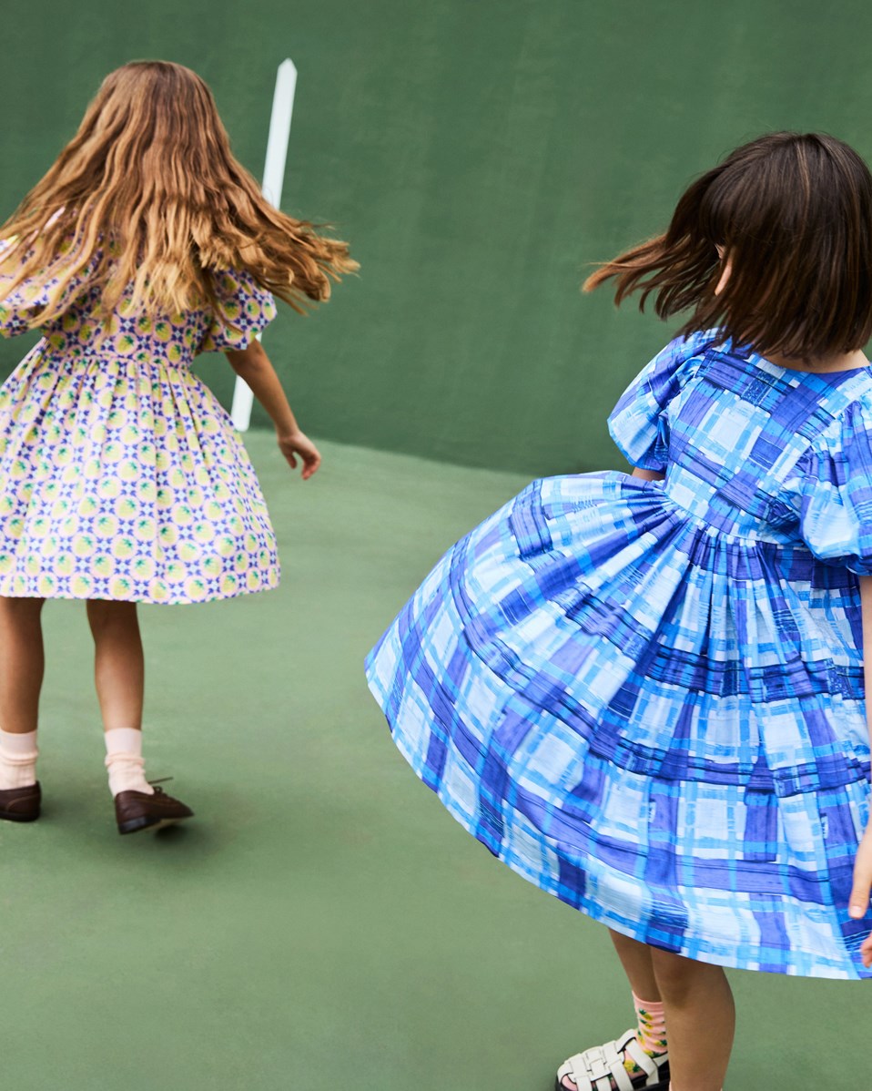 Caio - Vintage Berries - Knälång rosa klänning i ekologisk bomull med gula jordgubbar och vita blommor som blandas samman för att skapa ett vackert mönster.