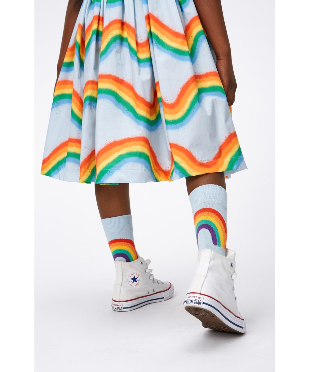 Calyita - Rainbow Waves - Ljusblå klänning i ekologisk bomull med regnbågar.