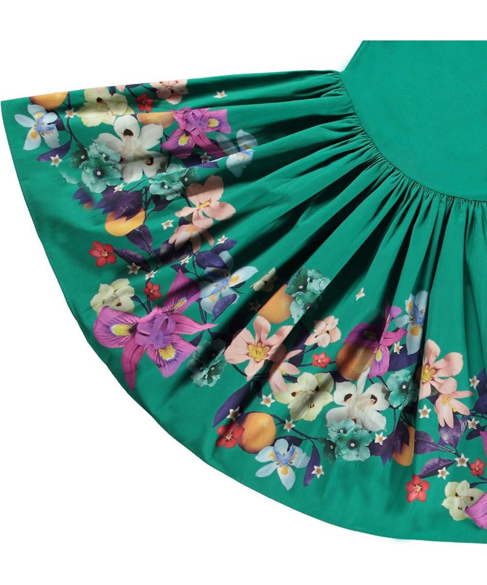 Casie - Colourful Garden - Grön ekologisk bomullsklänning med tajt ribbad topp och blommigt mönster.