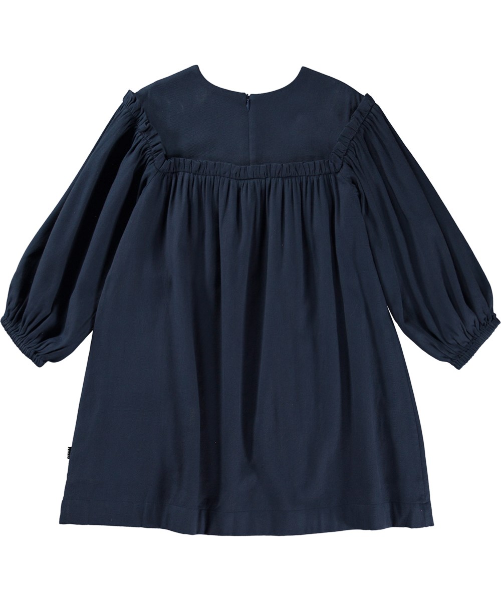 Cilla - Navy Sky - Mörkblå knälång klänning med volangdetaljer.