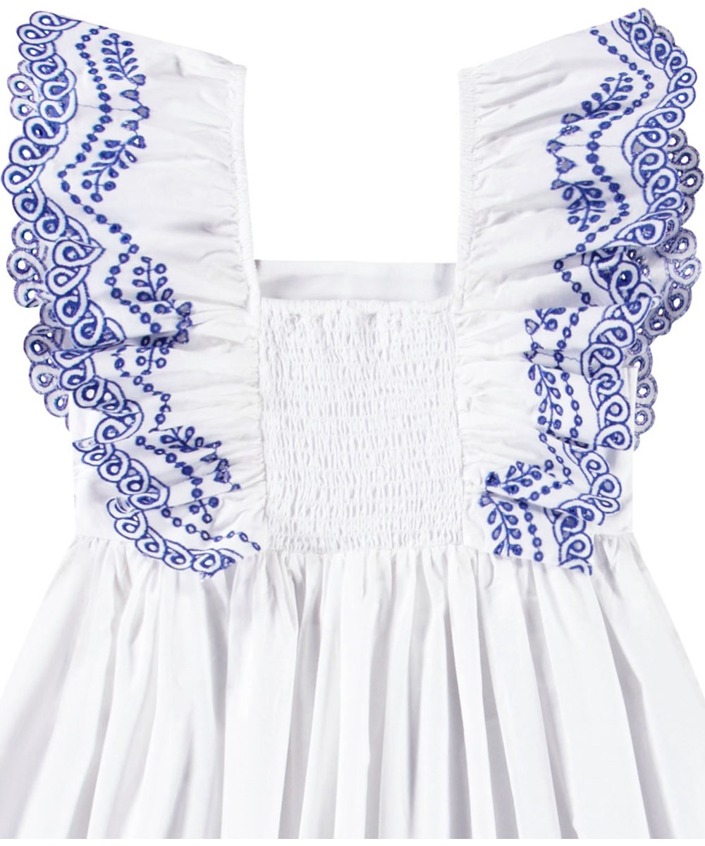 Clementine - Crisp White - Vit knälång klänning för barn i ekologisk bomull med broderie anglaise på kjolen och en volang över axeln.