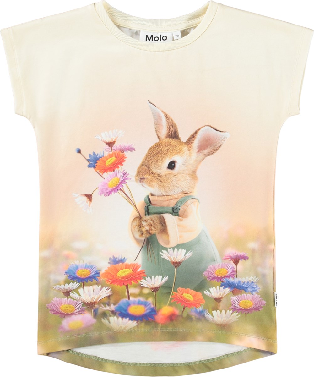 Ragnhilde - Bunny Rabbit - Ljusorange kortärmad T-shirt för barn i ekologisk bomull med en kanin i ett färgglatt blomsterfält.