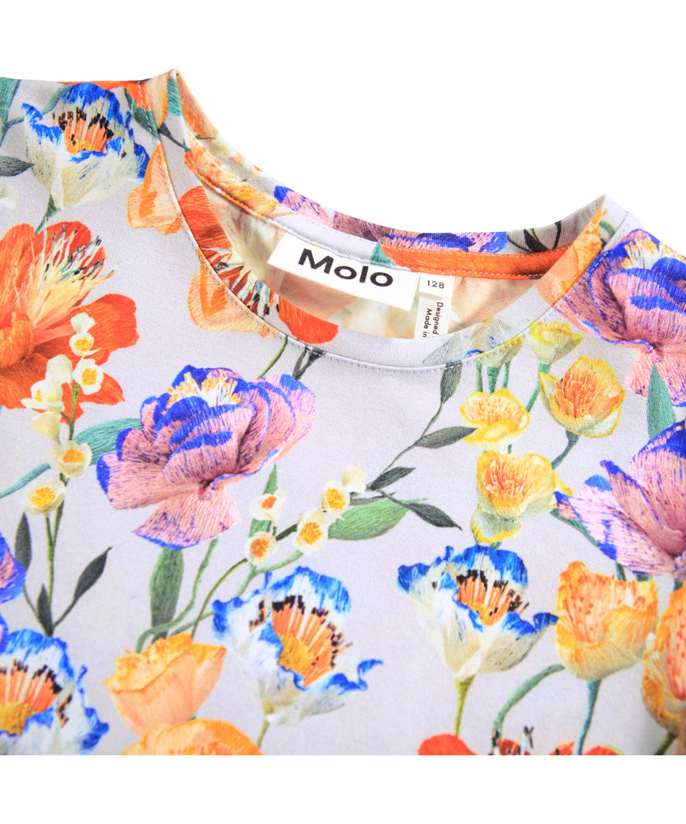 Rimona - Paper Flowers - Ljusblå, figursydd T-shirt för barn i mjuk ekologisk bomull med en rund hals och små korta puffärmar. T-shirten har ett färgglatt mönster av pappersblommor.