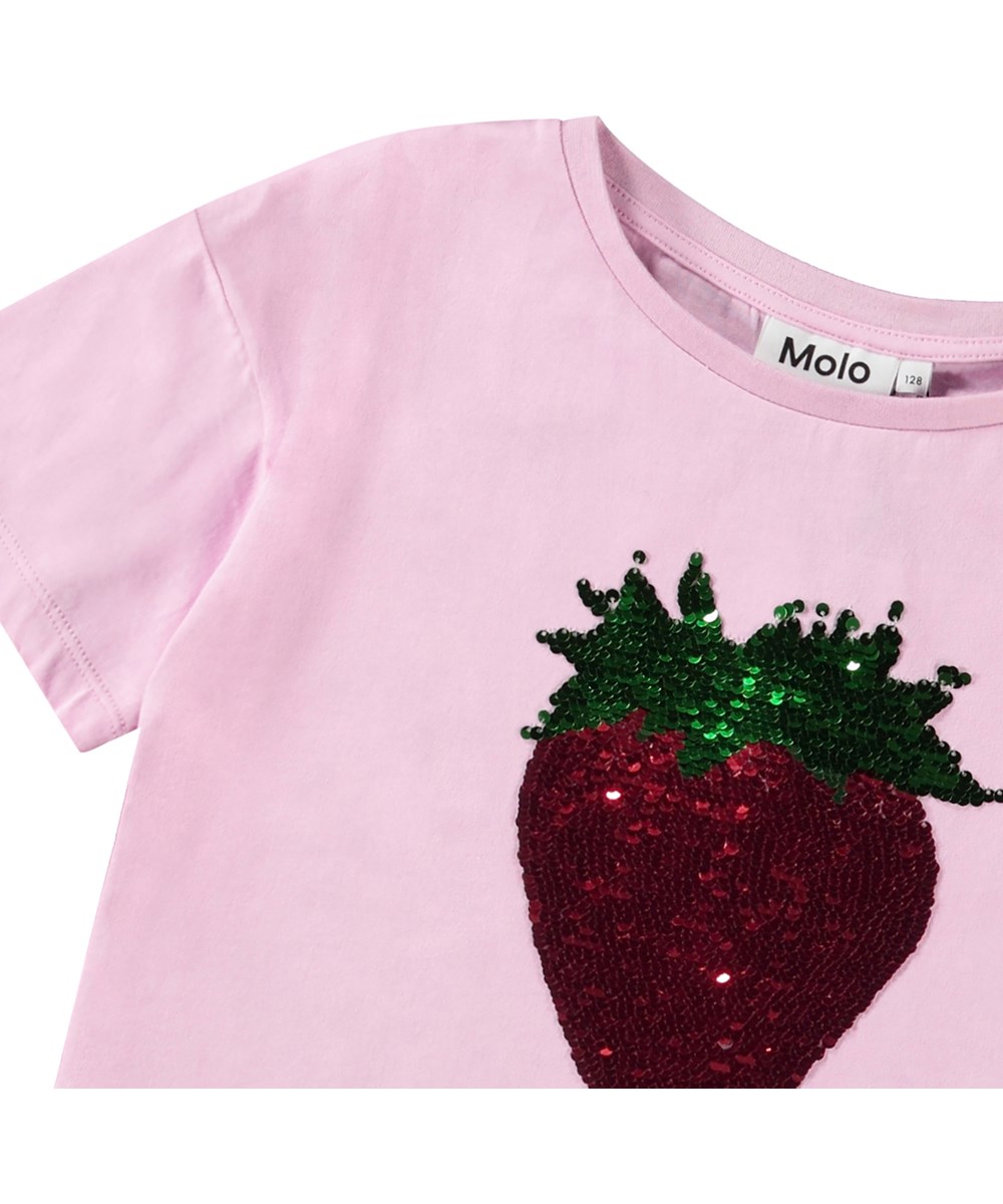 Roseanna - Glitter Strawberry - Oversized rosa T-shirt för barn i ekologisk bomull med ribbad halsringning och vändbara paljetter i form av jordgubbar på framsidan.