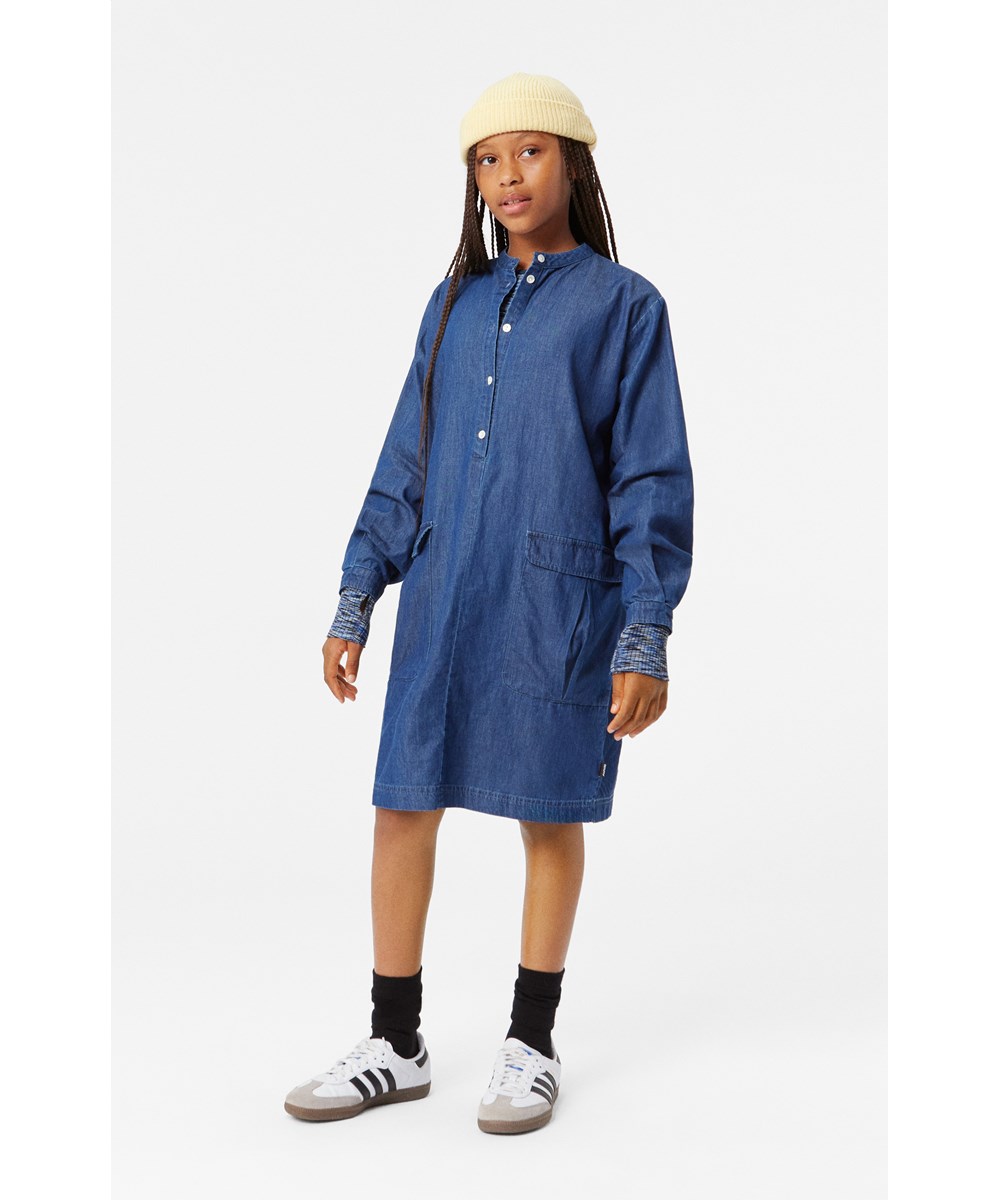 Caela - Mid Blue Wash - Relaxed knee-length blue denim dress in organic cotton with cargo pockets.