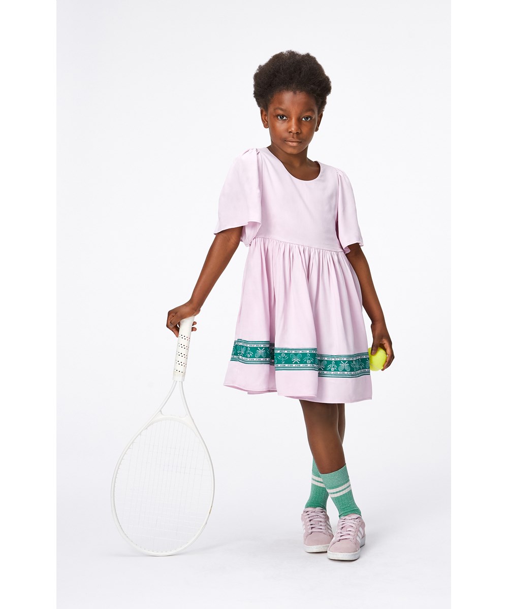 Carlin - Alpine Glow - Pink viscose dress with a green, printed border with flowers and tennis racquets