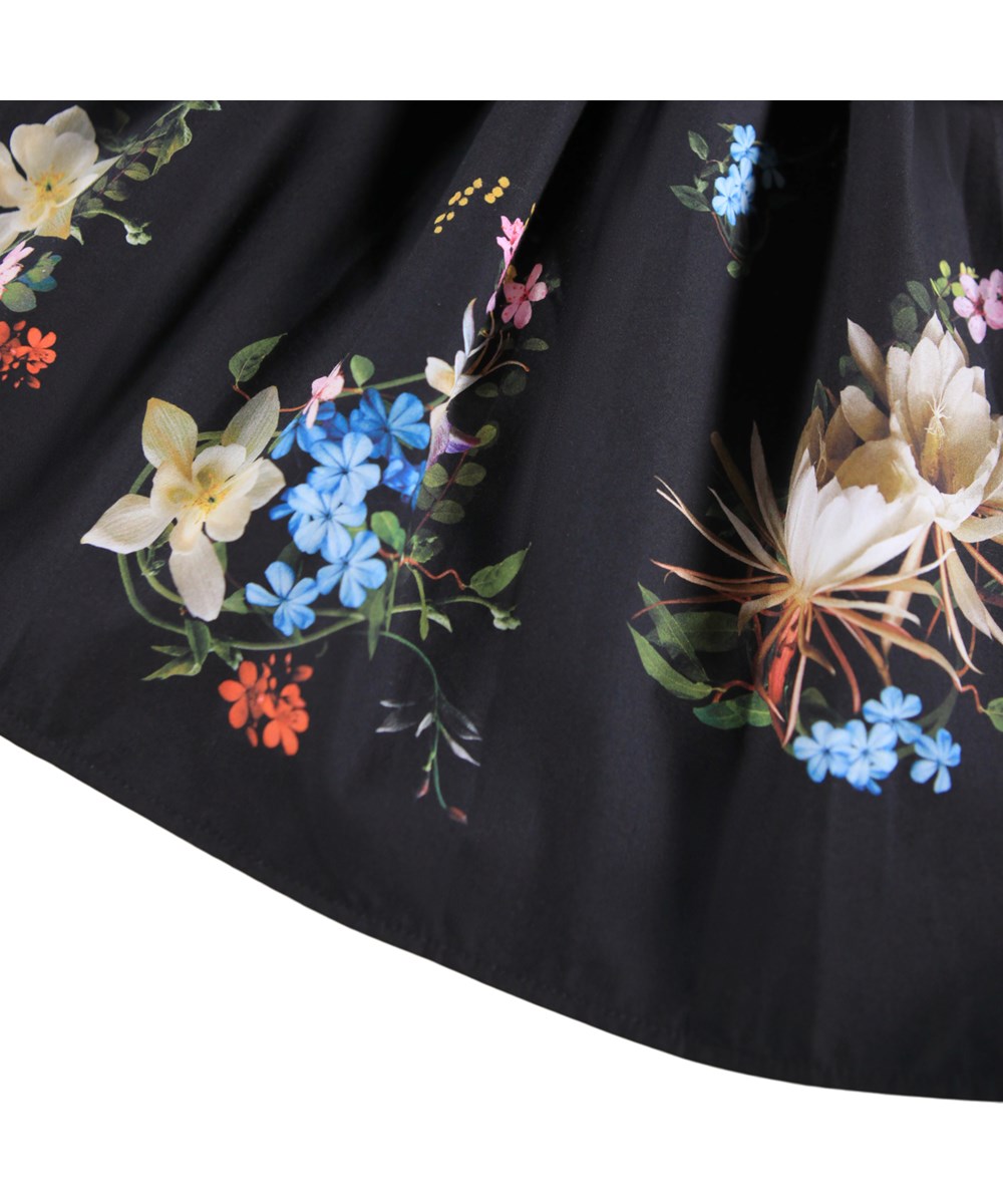 Casie - Paisley Border - Long-sleeved black dress for children made of organic cotton with a poplin skirt and a floral print.