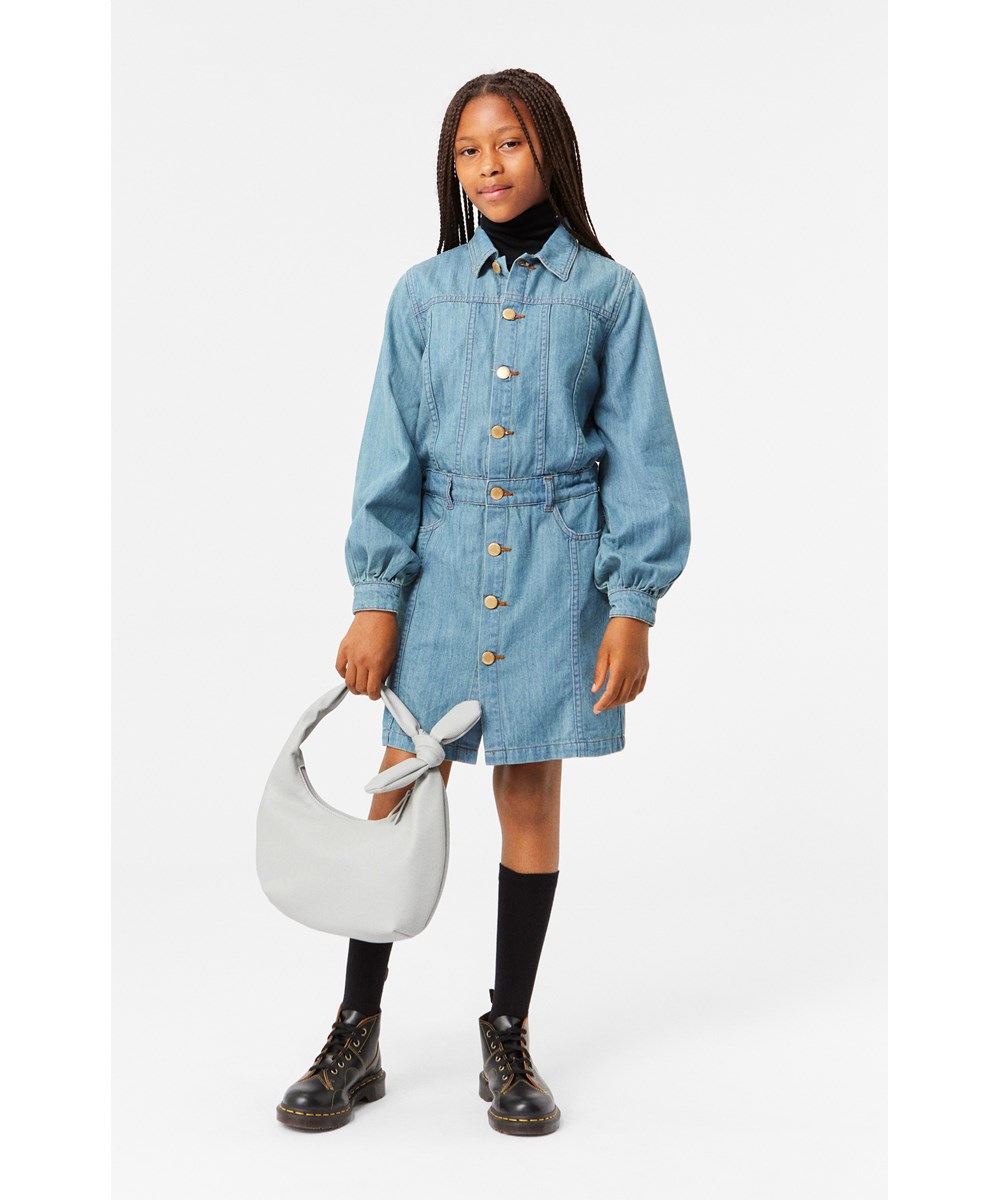 Chaya - Washed Denim Blue - Light blue denim dress with front pockets, long sleeves, and gold buttons.