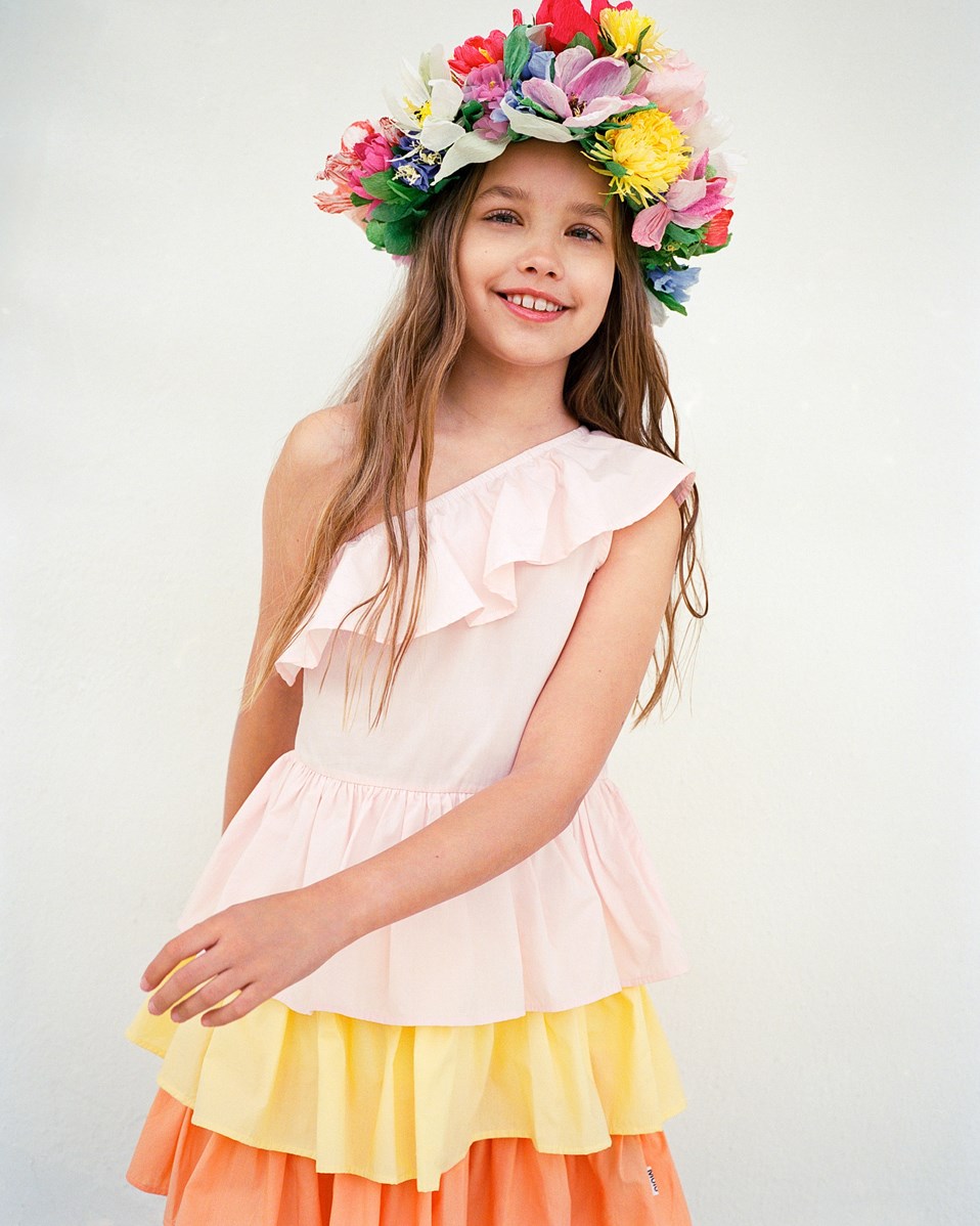 Cora - Charlotte Pink - Pink, orange, and yellow one-shoulder dress for children in organic cotton with elastic and ruffle detail on the shoulder.