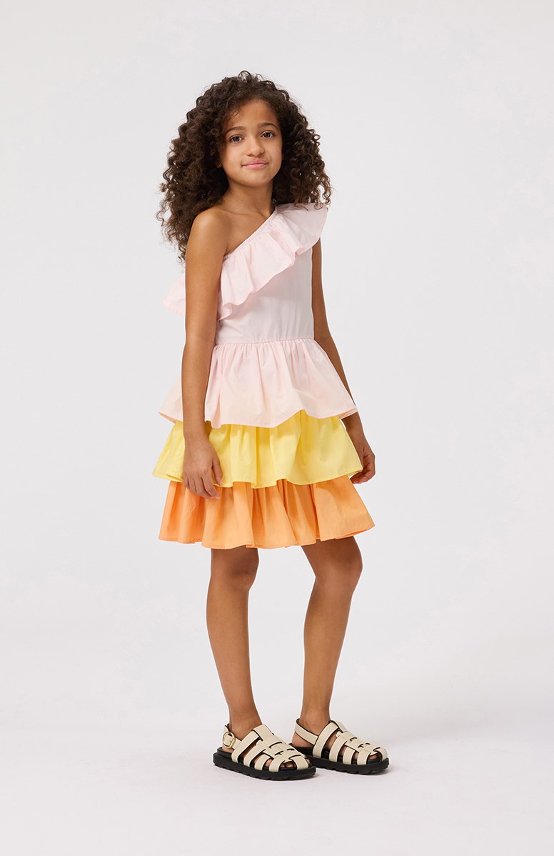 Cora - Charlotte Pink - Pink, orange, and yellow one-shoulder dress for children in organic cotton with elastic and ruffle detail on the shoulder.
