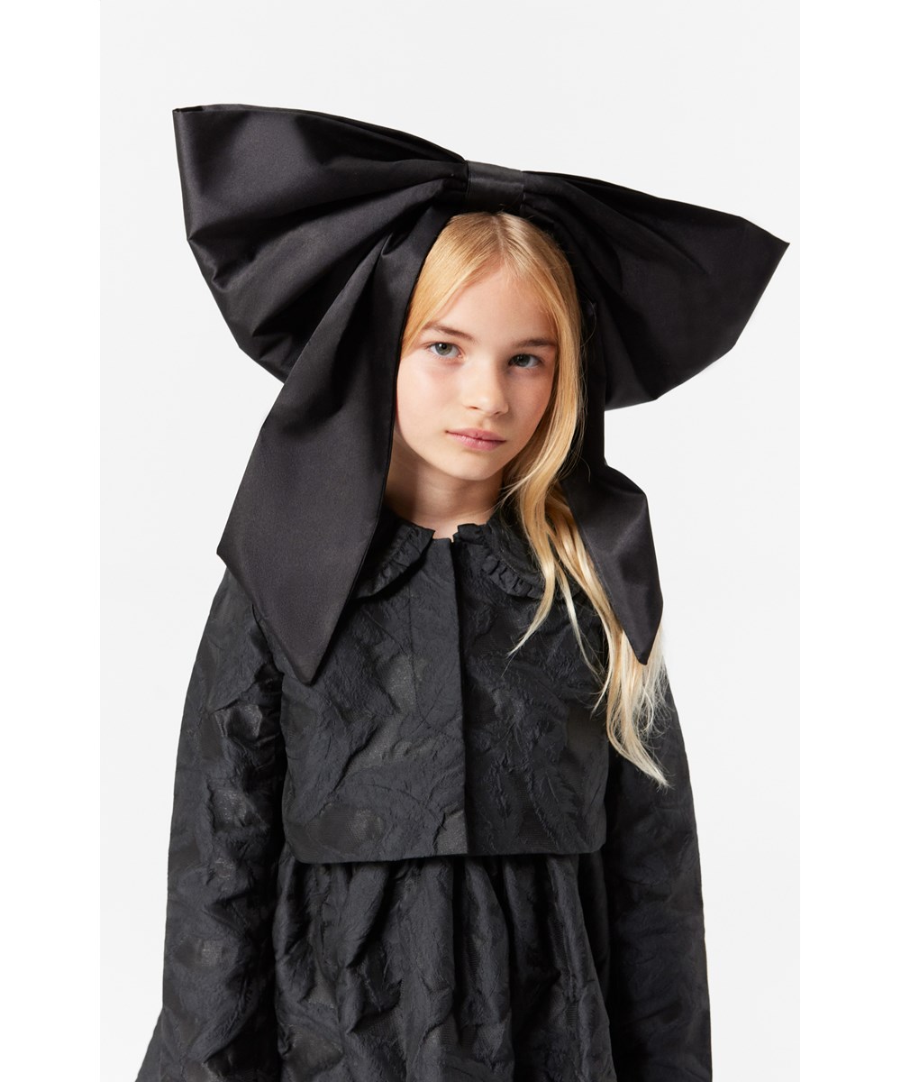 Cortney - Black - Sophisticated black knee-length dress with delicate ruffle edge and jacquard weave.