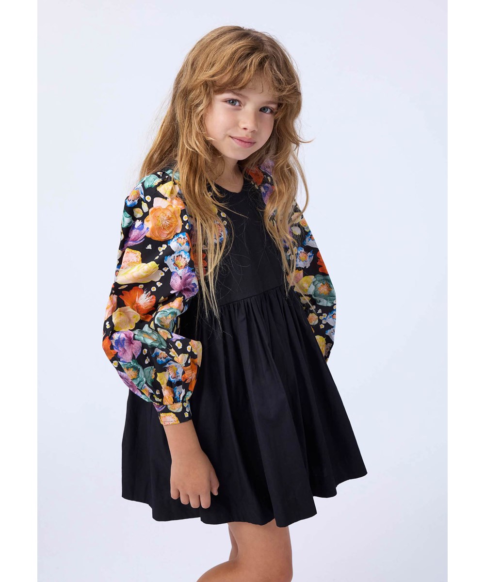 Cybil - Rainbow Flowers - Short black dress made of organic cotton poplin with a floral print.