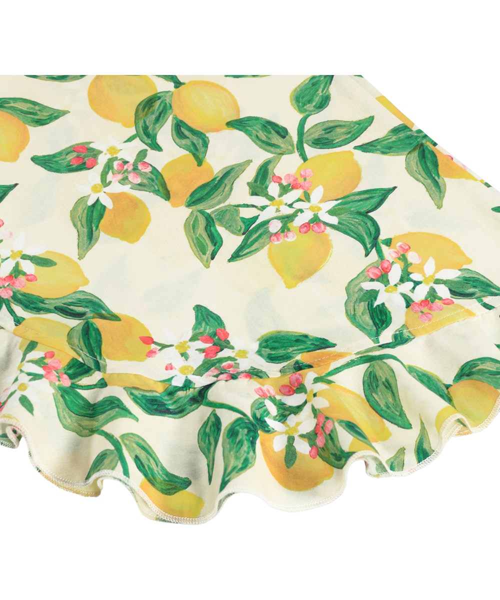 Aretha - Citrus - Yellow, loose trousers for children made of organic cotton with citrus print.