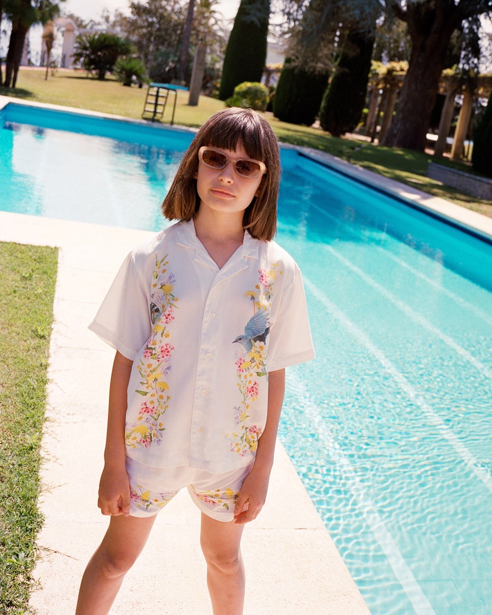 Adore - Picturesque - White short loose shorts in viscose for children with floral print along the bottom for children.