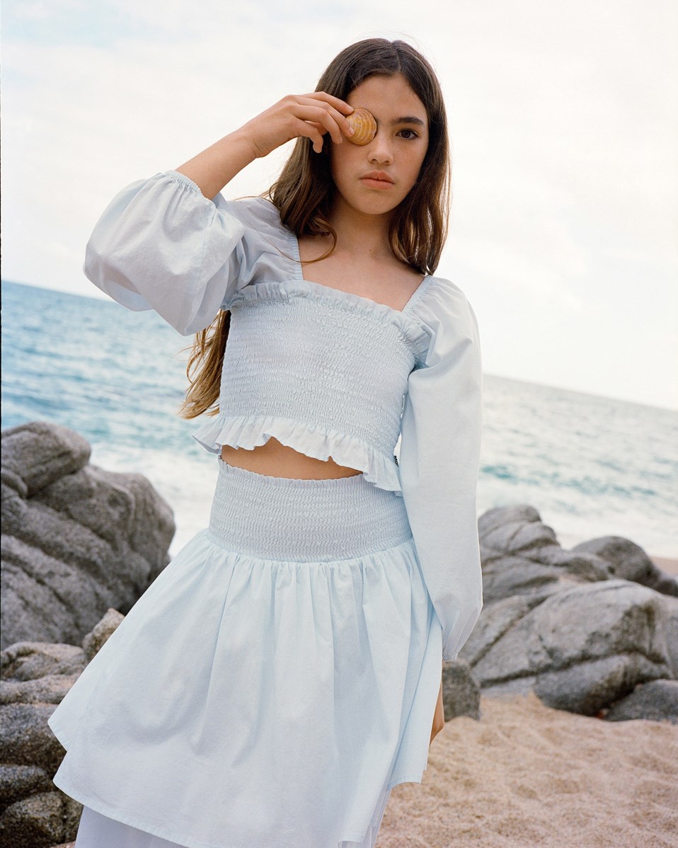 Brenna - Skywriting - Light blue long skirt with a wide smocked waistband for children.