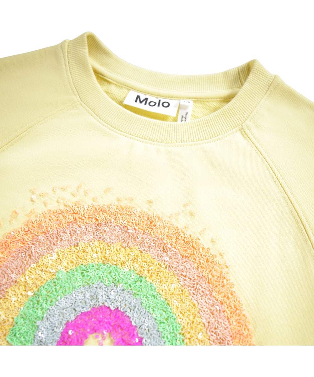 Marilee - Mellow Yellow - Light yellow sweatshirt for children made of organic cotton with a sequin rainbow.