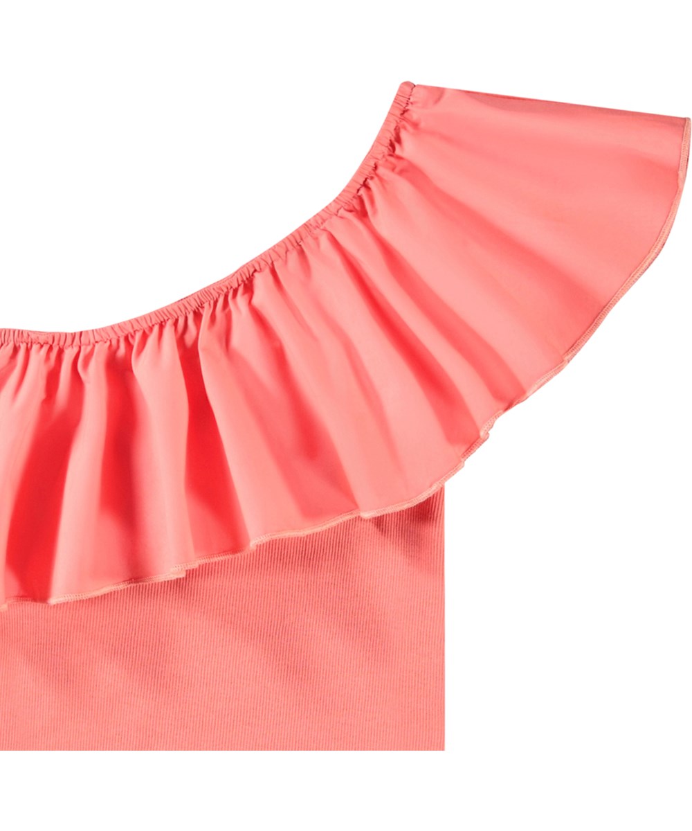 Rebecca - Warm Coral - Coral-coloured one-shoulder top for children in organic cotton with stretch.
