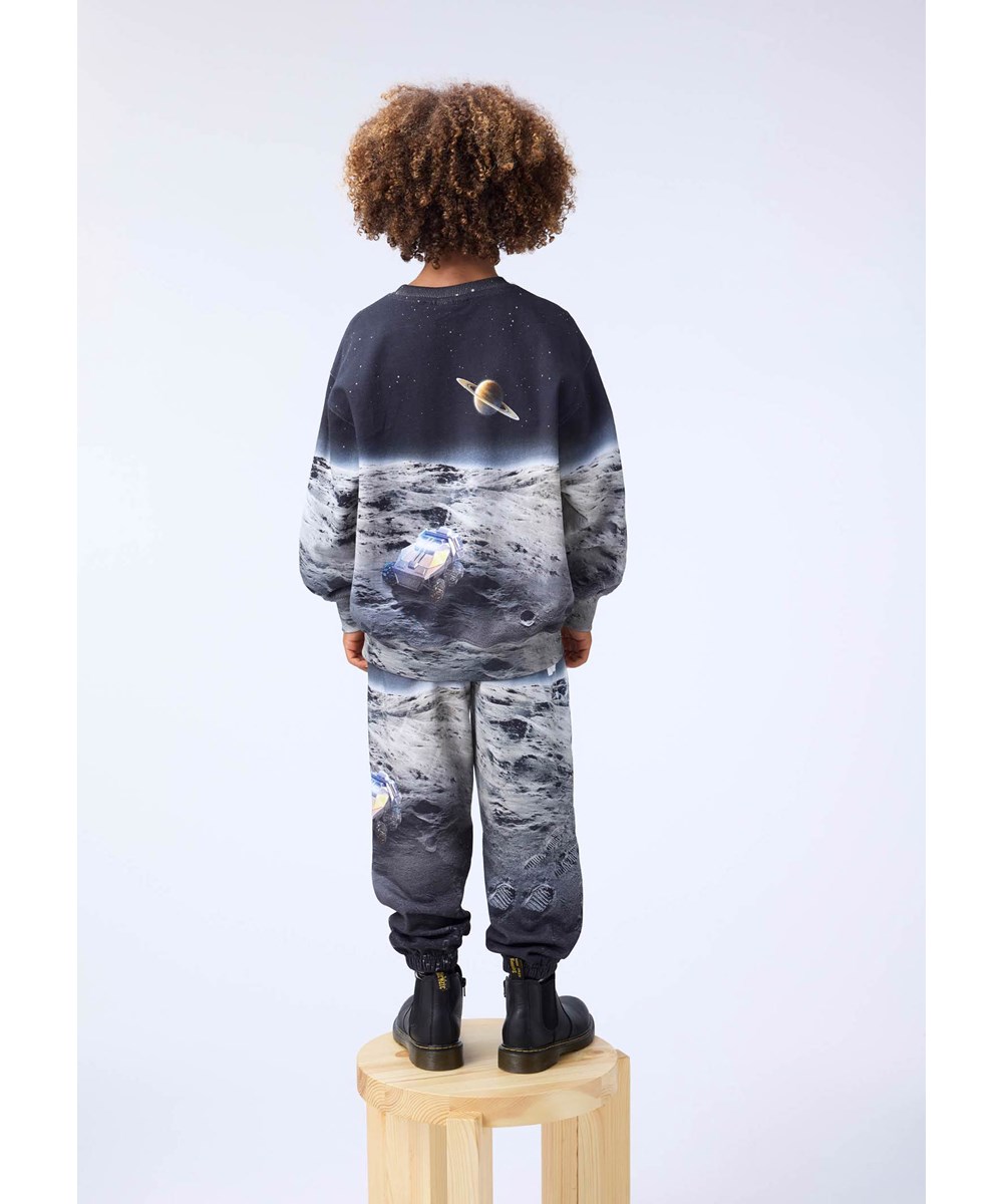 Allen - Moon Traveller - Kleurrijke joggingbroek voor kinderen gemaakt van biologisch katoen met een print van de maan.