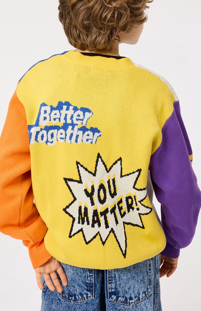 Burt - You Matter! - Kleurrijke gebreide kindervest van biologisch katoen met een v-hals, ribboord rond de hals, mouwen en onderkant en knopen aan de voorkant.
